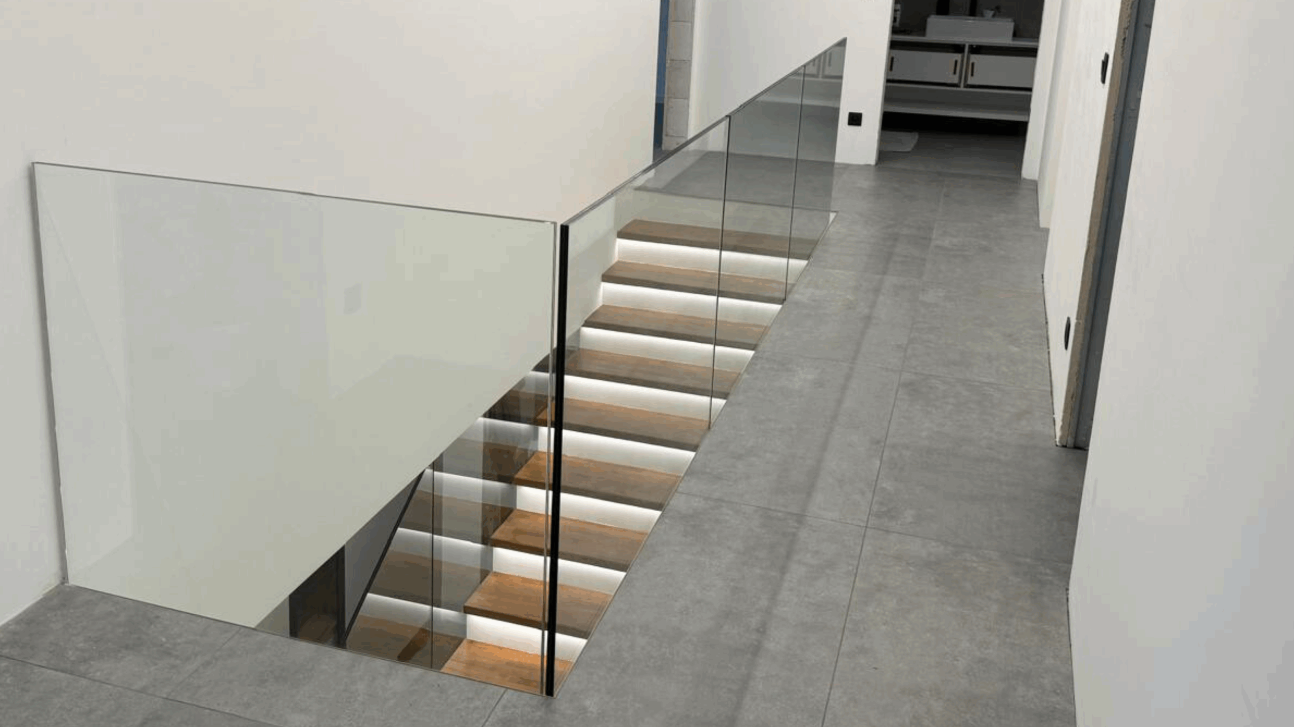 Dřevěný obklad schodiště s celoskleněným zábradlím