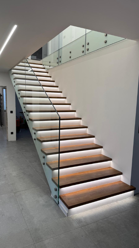 Dřevěný obklad schodiště s celoskleněným zábradlím