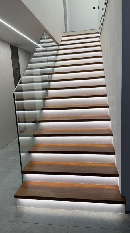 Dřevěný obklad schodiště s celoskleněným zábradlím