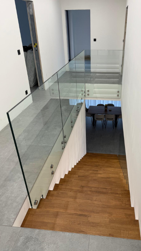 Dřevěný obklad schodiště s celoskleněným zábradlím