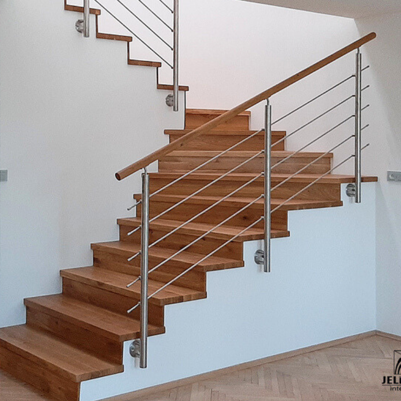 Moderní nerezové zábradlí s prutovou výplní a dřevěným madlem. Realizace zahrnuje také obklad schodiště z masivního dubu v úpravě RUSTIK.